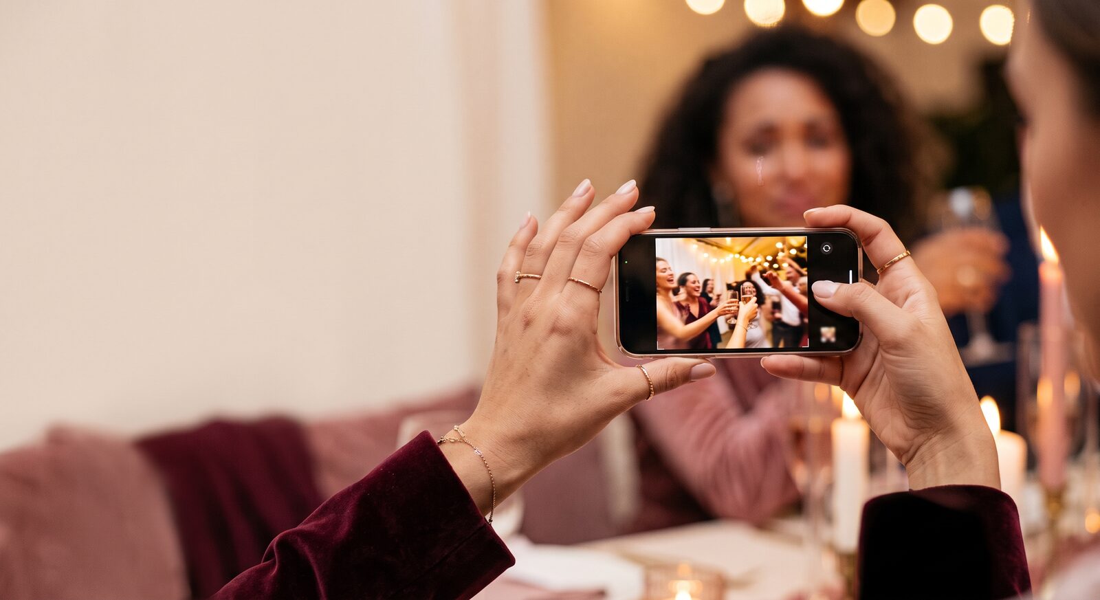 Uma convidada registra o evento usando o celular.